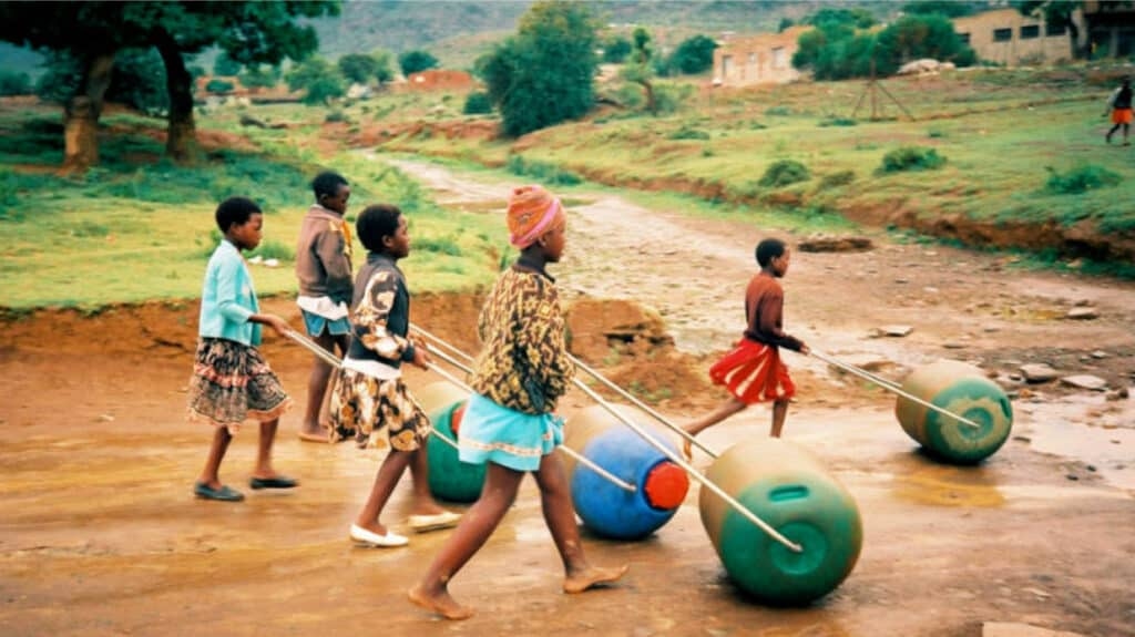 Foto: Kinder in Afrika, die einen Hippo-Roller schieben.